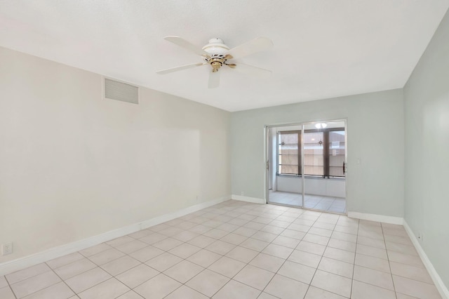 tiled spare room with ceiling fan