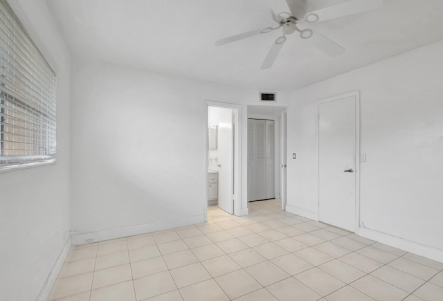 tiled empty room featuring ceiling fan