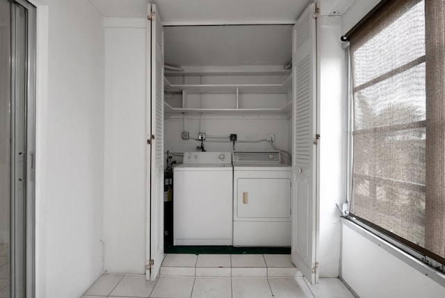 clothes washing area featuring independent washer and dryer and light tile patterned flooring