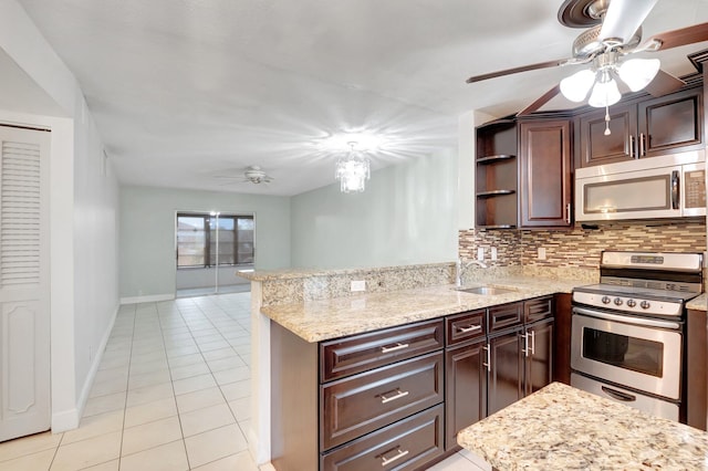 kitchen featuring kitchen peninsula, appliances with stainless steel finishes, decorative backsplash, dark brown cabinetry, and sink