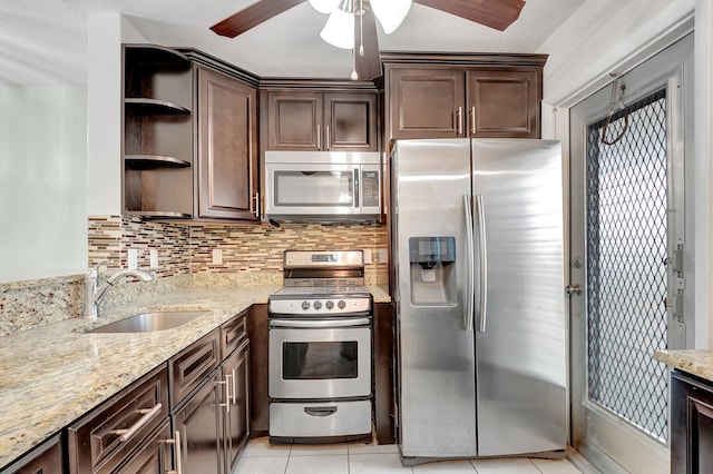 kitchen featuring ceiling fan, stainless steel appliances, decorative backsplash, dark brown cabinets, and sink