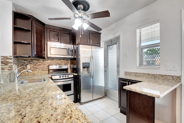 kitchen with light stone counters, sink, appliances with stainless steel finishes, and ceiling fan