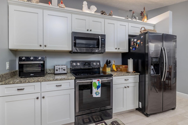 kitchen with white cabinets, stone counters, and appliances with stainless steel finishes