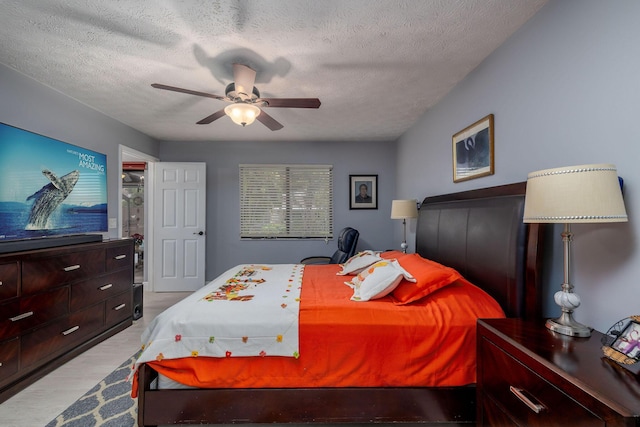 bedroom with ceiling fan and a textured ceiling