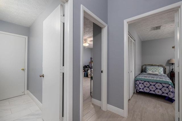 hallway with a textured ceiling