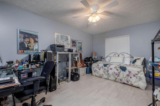 bedroom with ceiling fan, a textured ceiling, and light wood-type flooring