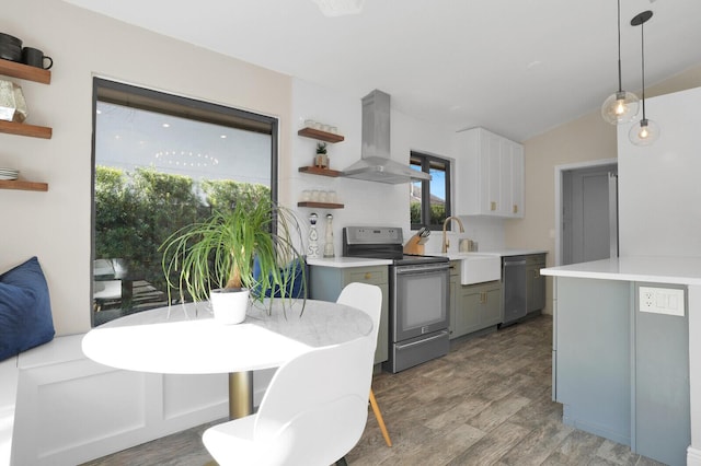 kitchen featuring decorative light fixtures, gray cabinets, sink, appliances with stainless steel finishes, and wall chimney exhaust hood