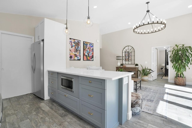 kitchen with pendant lighting, appliances with stainless steel finishes, and dark hardwood / wood-style floors