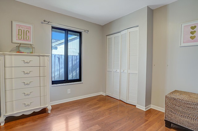 bedroom with light wood-type flooring and a closet