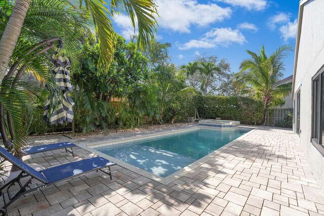 view of pool featuring a patio area and an in ground hot tub