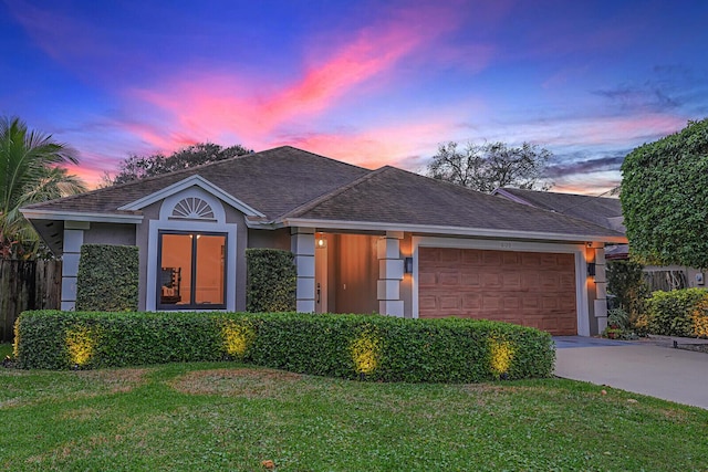 single story home with a garage and a lawn