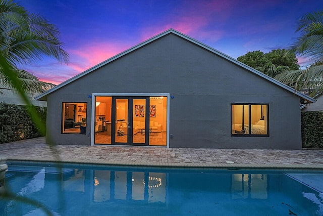 back house at dusk with a patio area