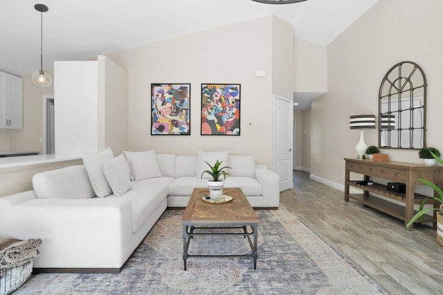 living room with light hardwood / wood-style flooring and high vaulted ceiling