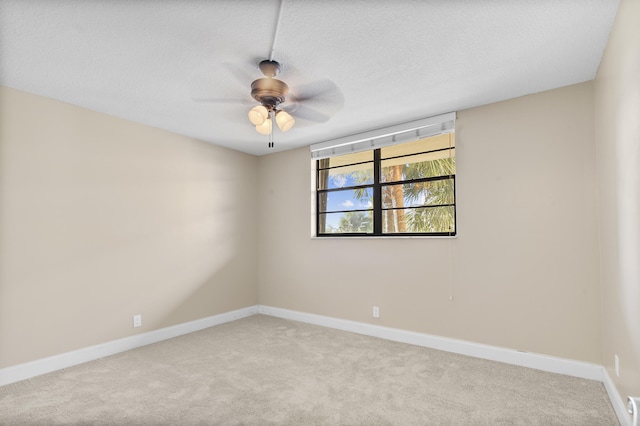 carpeted spare room featuring ceiling fan and a textured ceiling