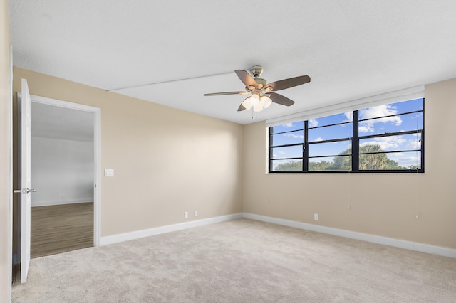 carpeted spare room with ceiling fan