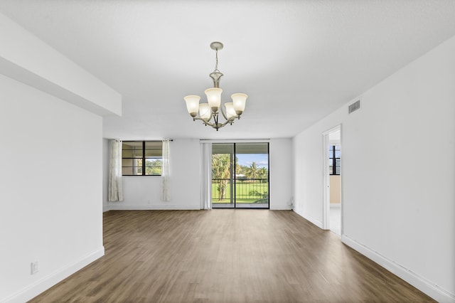 empty room featuring dark hardwood / wood-style floors and a chandelier