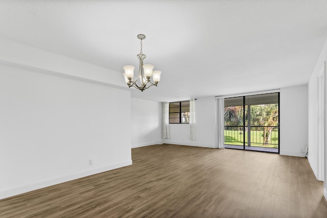 spare room with a chandelier and hardwood / wood-style flooring