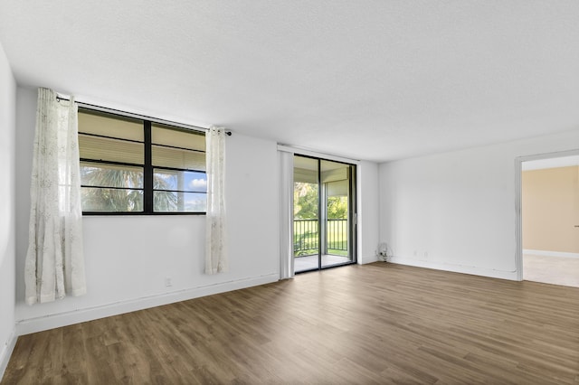 unfurnished room featuring a textured ceiling and hardwood / wood-style flooring