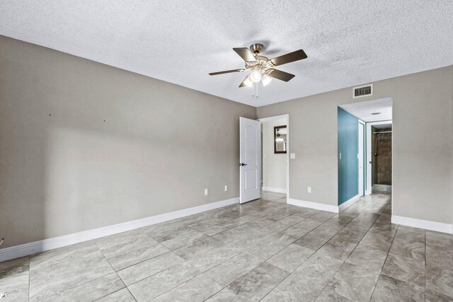 spare room featuring ceiling fan and a textured ceiling