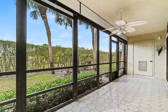 unfurnished sunroom with ceiling fan