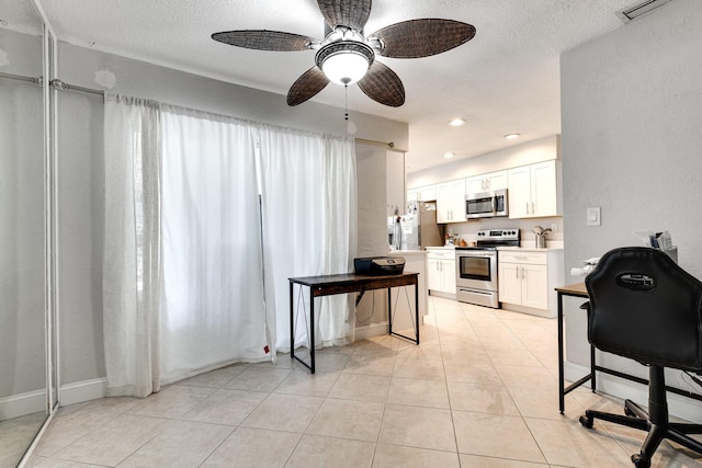 kitchen featuring ceiling fan, white cabinetry, appliances with stainless steel finishes, a textured ceiling, and light tile patterned floors