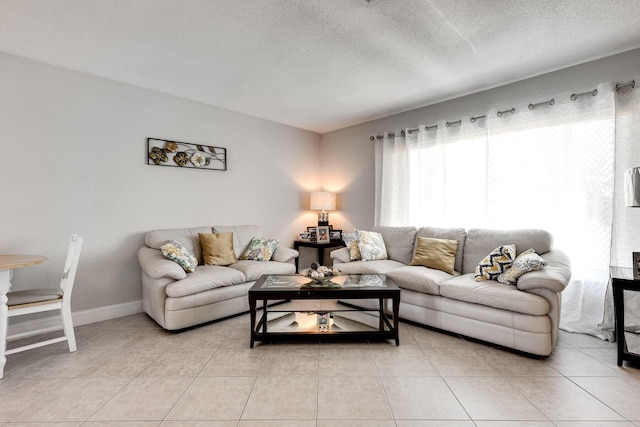 living room featuring a textured ceiling and light tile patterned floors