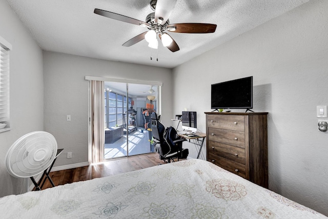 bedroom featuring ceiling fan, access to exterior, a textured ceiling, and wood-type flooring