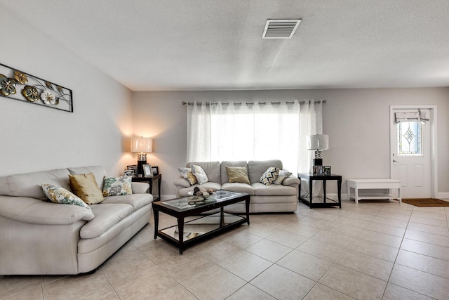 living room featuring a textured ceiling and light tile patterned flooring