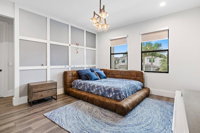 bedroom featuring wood-type flooring and a notable chandelier