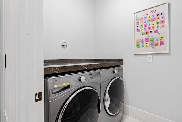 clothes washing area with washing machine and dryer