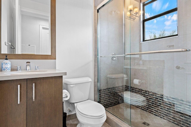 bathroom with vanity, a shower with door, and toilet