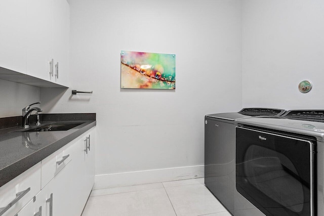 laundry room featuring washer and dryer, sink, light tile patterned floors, and cabinets