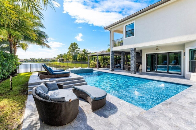 view of swimming pool with pool water feature, ceiling fan, and a patio