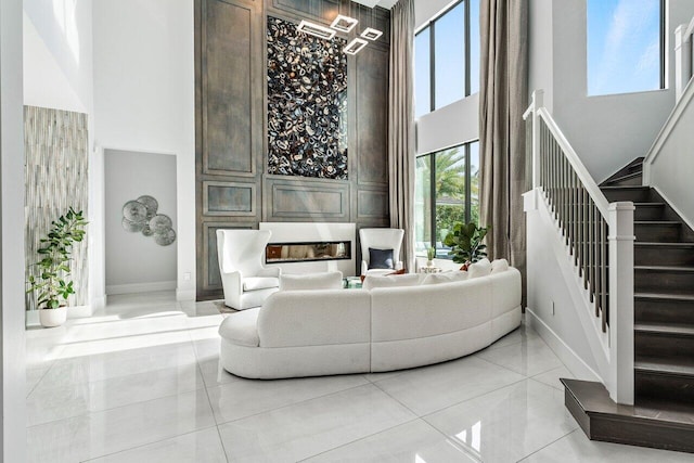 living room with light tile patterned flooring and a towering ceiling