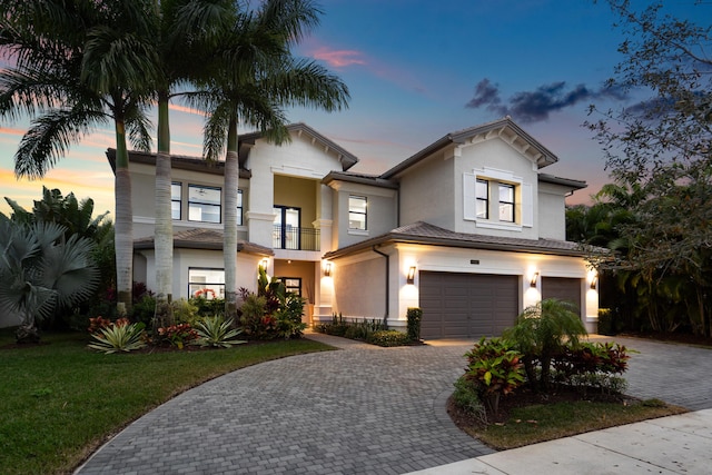 9748 Rennes Ln, Delray Beach, FL 33446 - view of front of house featuring a garage, a balcony, decorative driveway, stucco siding, and a yard
