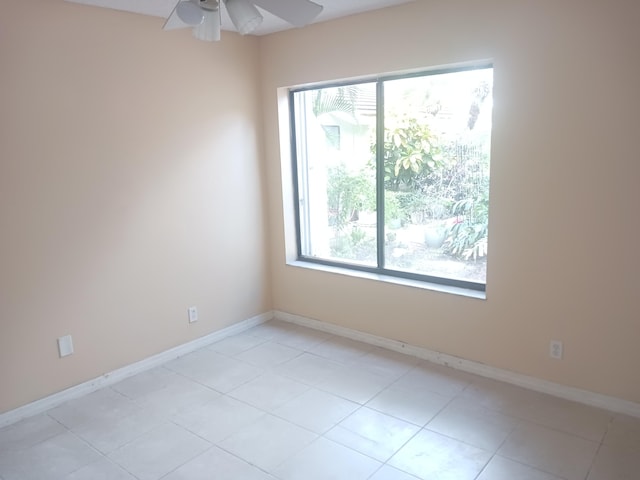 spare room featuring light tile patterned flooring and ceiling fan