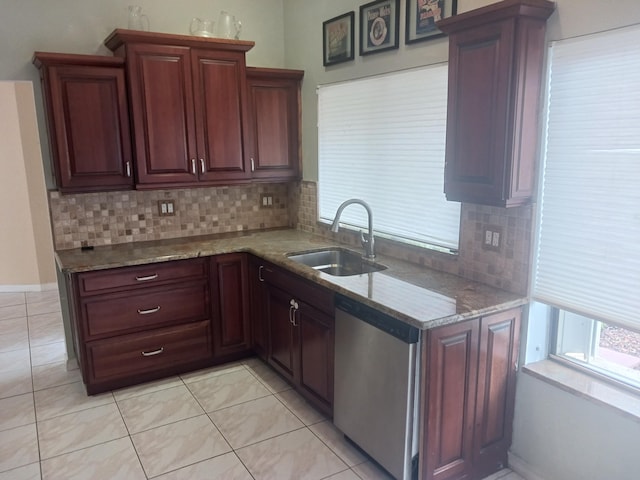 kitchen with light stone countertops, sink, stainless steel dishwasher, and backsplash