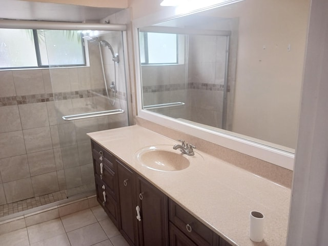 bathroom featuring a wealth of natural light, tile patterned floors, and a shower with shower door