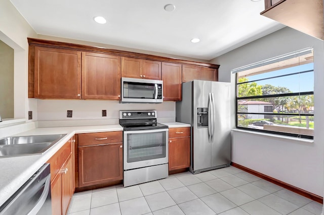 kitchen featuring light countertops, appliances with stainless steel finishes, brown cabinetry, and recessed lighting