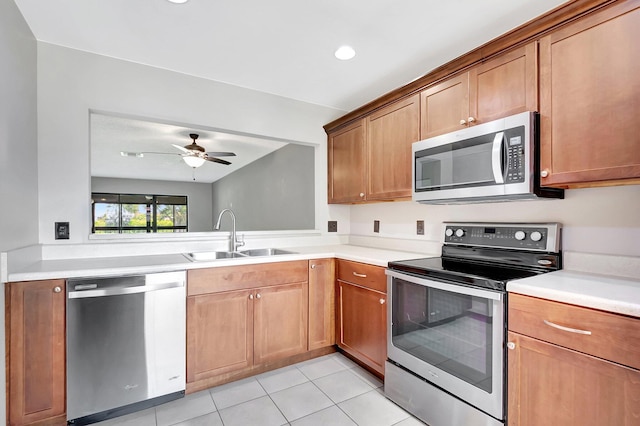 kitchen with light tile patterned flooring, stainless steel appliances, a sink, and light countertops