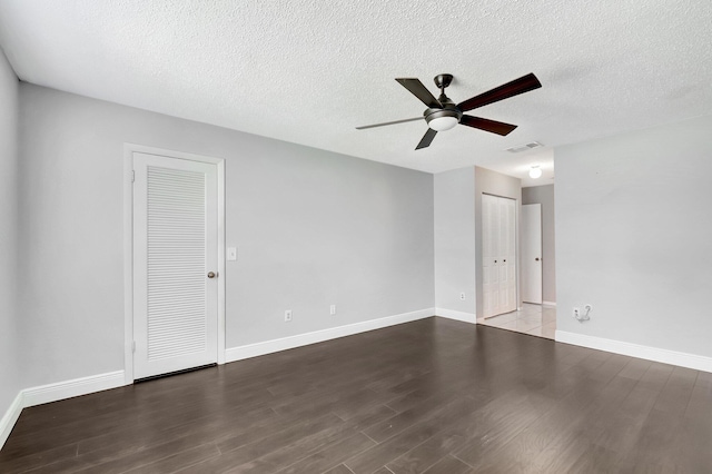 empty room featuring baseboards, visible vents, ceiling fan, wood finished floors, and a textured ceiling