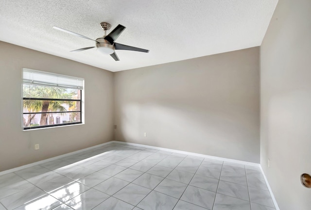 empty room with ceiling fan, baseboards, and a textured ceiling