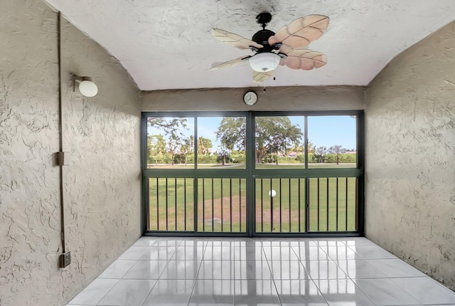 unfurnished sunroom with a ceiling fan and lofted ceiling