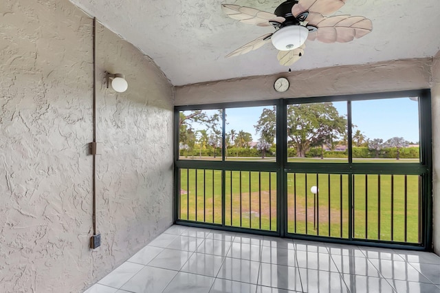 unfurnished sunroom with a ceiling fan and a healthy amount of sunlight