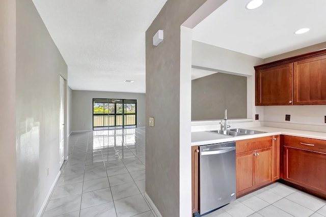 kitchen featuring light tile patterned floors, baseboards, light countertops, stainless steel dishwasher, and a sink