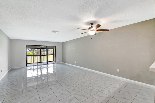 spare room with baseboards, visible vents, ceiling fan, and a textured ceiling