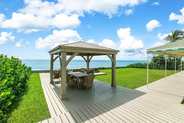 wooden terrace with a water view, a gazebo, and a yard