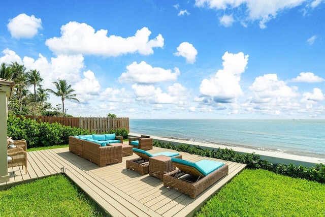 deck featuring a water view, a lawn, outdoor lounge area, and a view of the beach