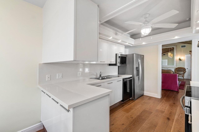 kitchen featuring backsplash, light wood-type flooring, appliances with stainless steel finishes, and white cabinetry