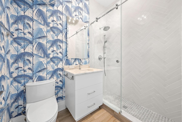 bathroom featuring wood-type flooring, toilet, vanity, and walk in shower